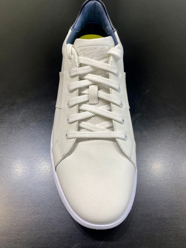 A pair of white sneakers with laces on a black surface.