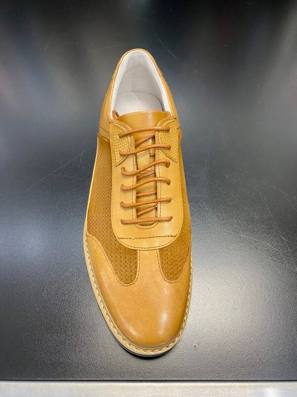 A pair of brown shoes with white laces on a black surface.
