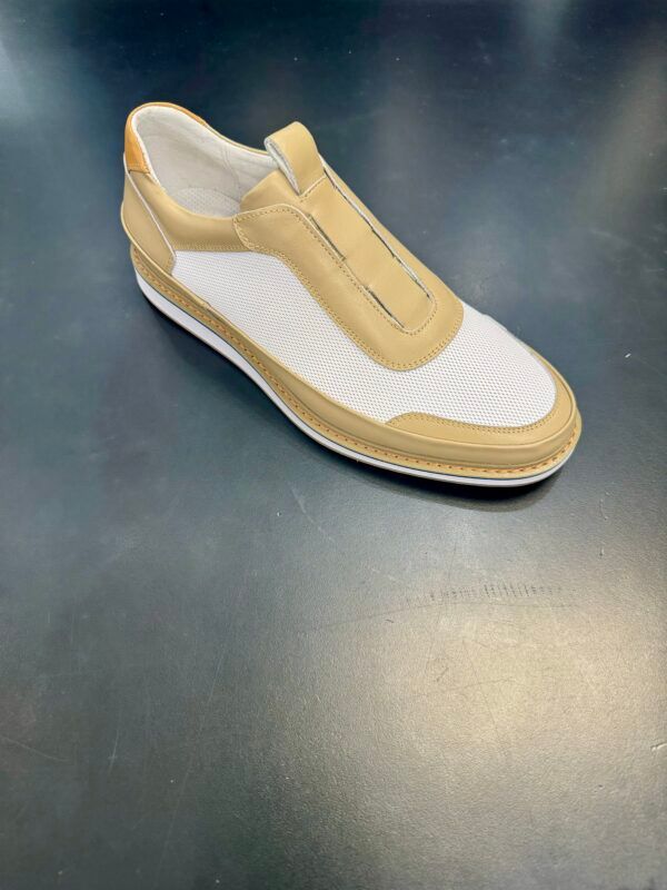 A pair of white and tan shoes on a black surface