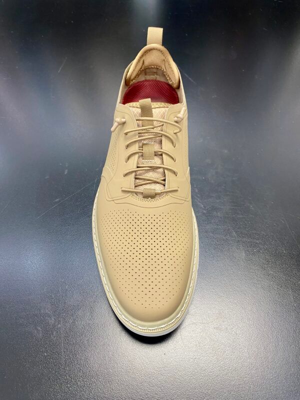 A pair of tan shoes are sitting on a black table.
