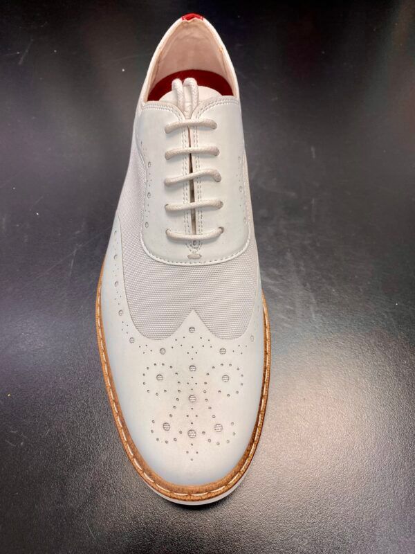 A pair of white shoes with brown soles and laces