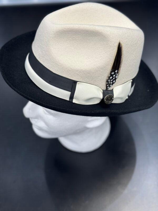 A black and white fedora hat with feathers on a mannequin head