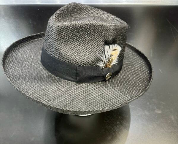 A black hat with feathers on it is sitting on a table.