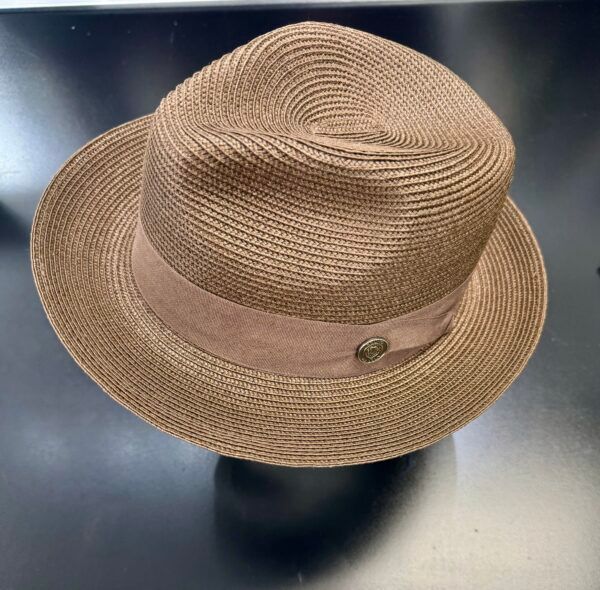 A brown straw hat with a pink band sits on a black surface
