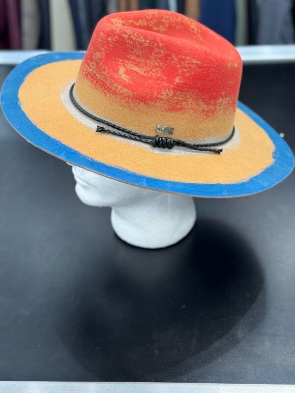 A red and yellow hat is on a mannequin head