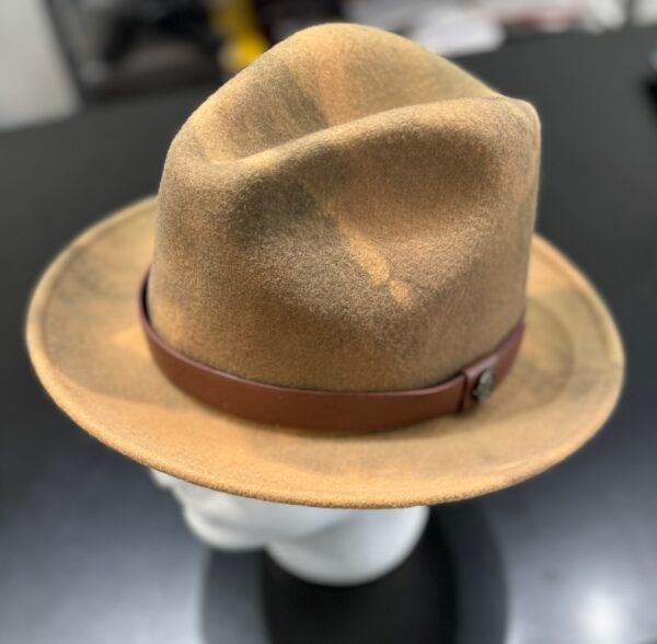 A tan hat with a brown band is on a mannequin head