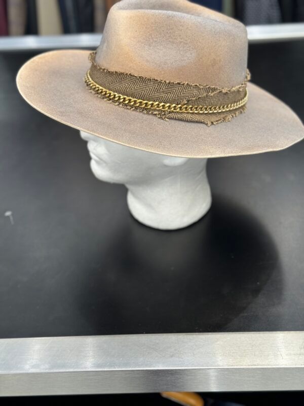 A hat is on a mannequin head on a table.