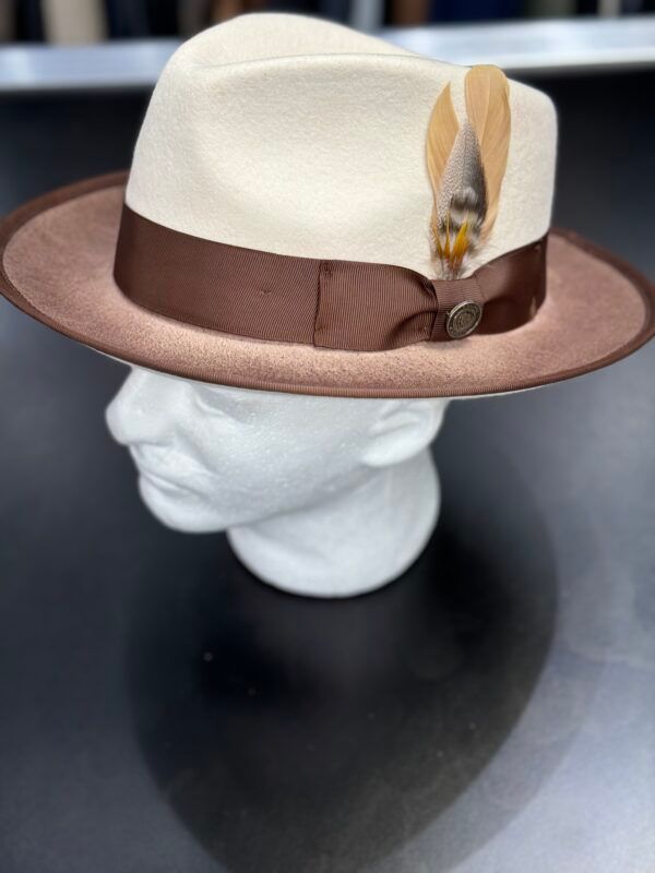 A white hat with brown feathers is on a mannequin head
