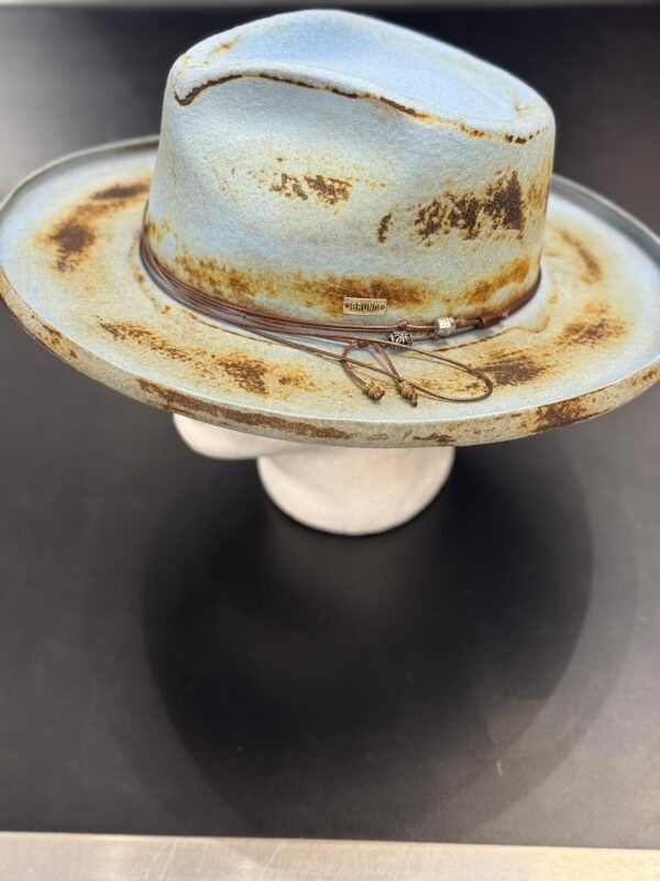 A cowboy hat is sitting on a white plate on a table.
