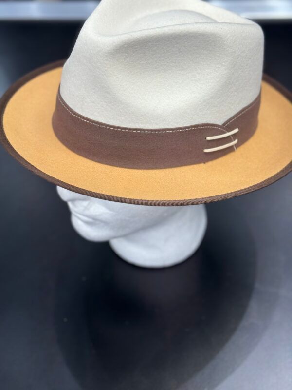 A white hat with a brown band is on a mannequin head