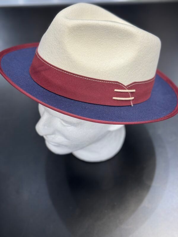 A white hat with a red band is on a mannequin head