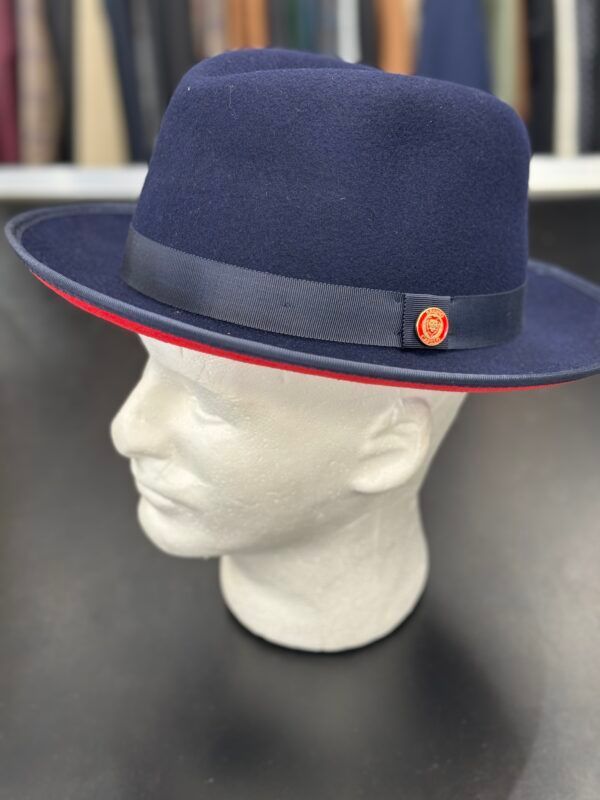 A blue fedora hat with a red ribbon is on a mannequin head.