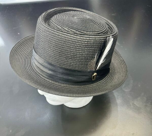 A black hat with a feather on it is sitting on a table.