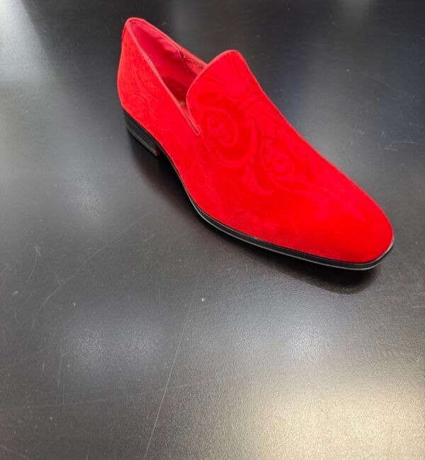 A pair of red shoes on a black surface