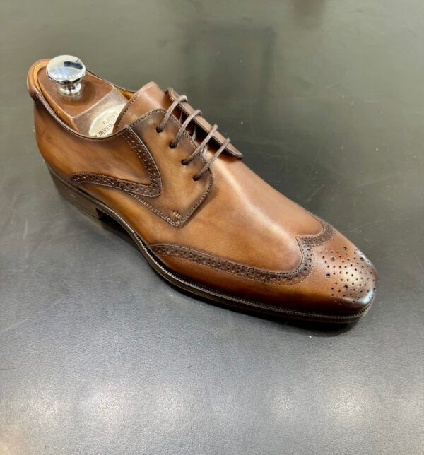 A brown shoe is sitting on a black surface