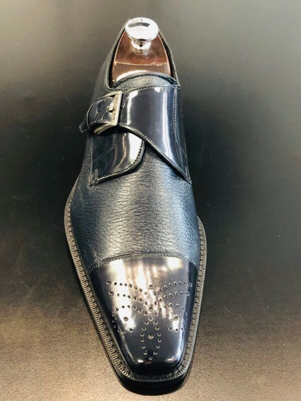 A close up of a pair of black shoes on a black surface.