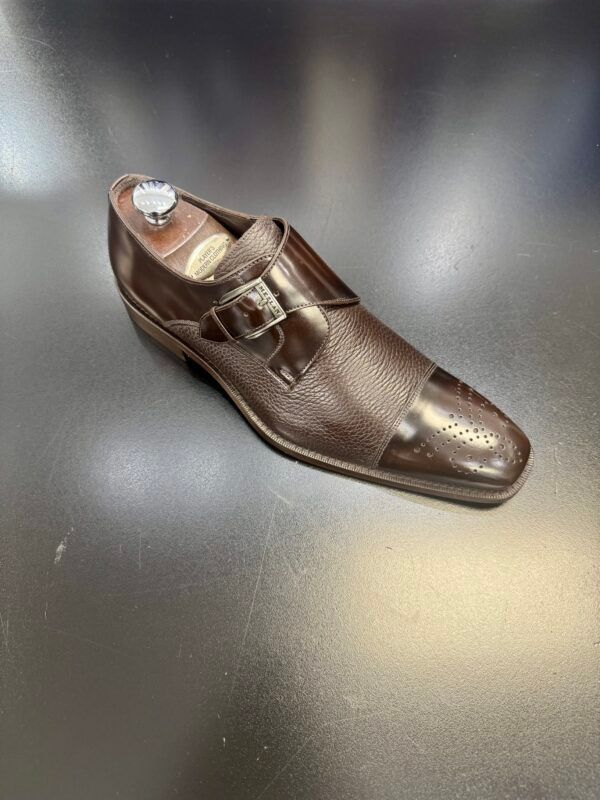 A brown shoe is sitting on top of a black table.