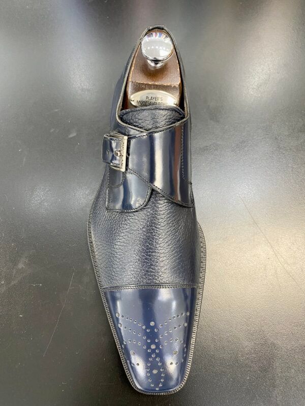 A close up of a pair of blue shoes on a black surface.