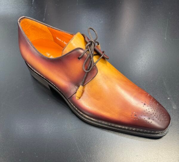 A pair of brown and yellow shoes on a black surface