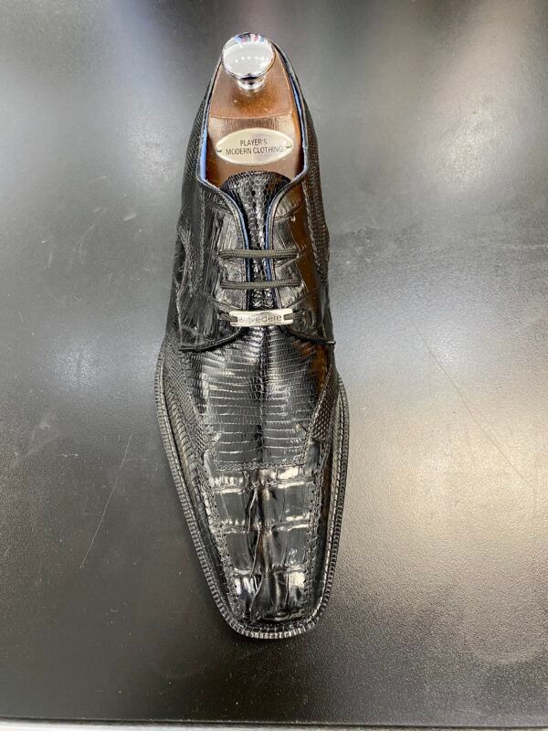 A pair of black shoes sitting on top of a black table.