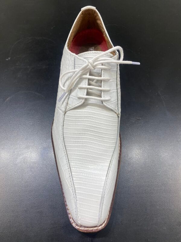 A pair of white shoes with red laces on a black surface