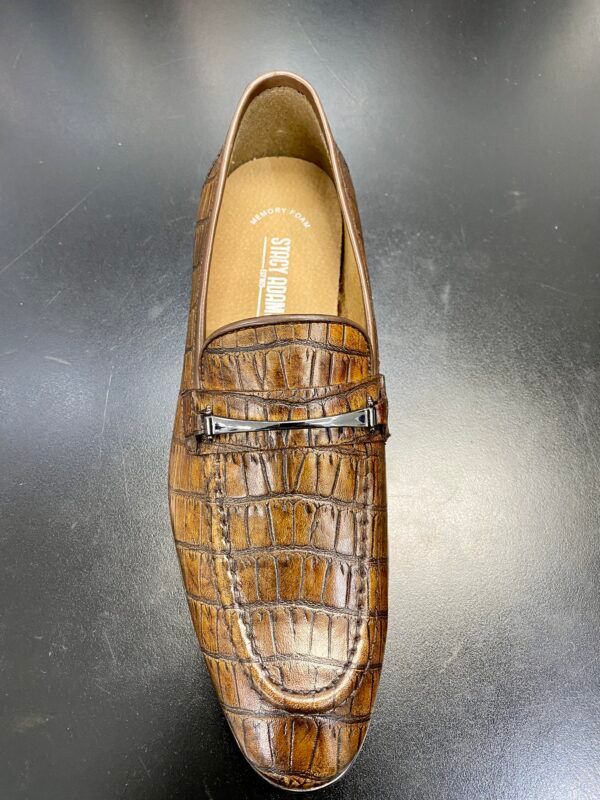 A pair of brown loafers are sitting on a black table.