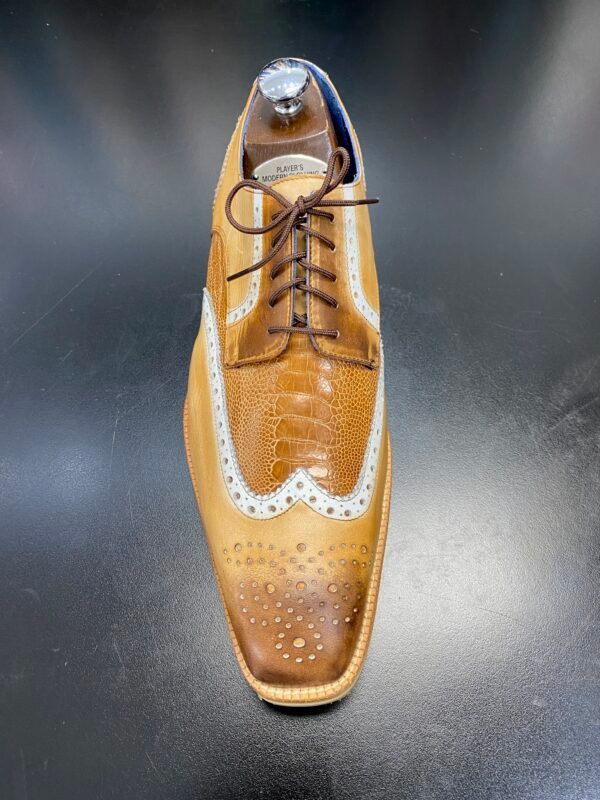 A pair of brown shoes with white laces on a black surface.