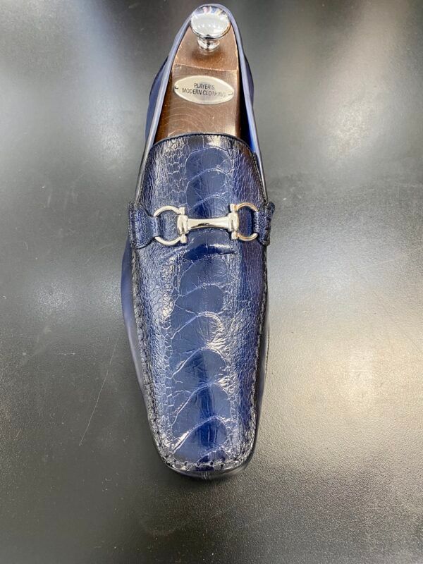 A pair of blue loafers sitting on top of a black table.