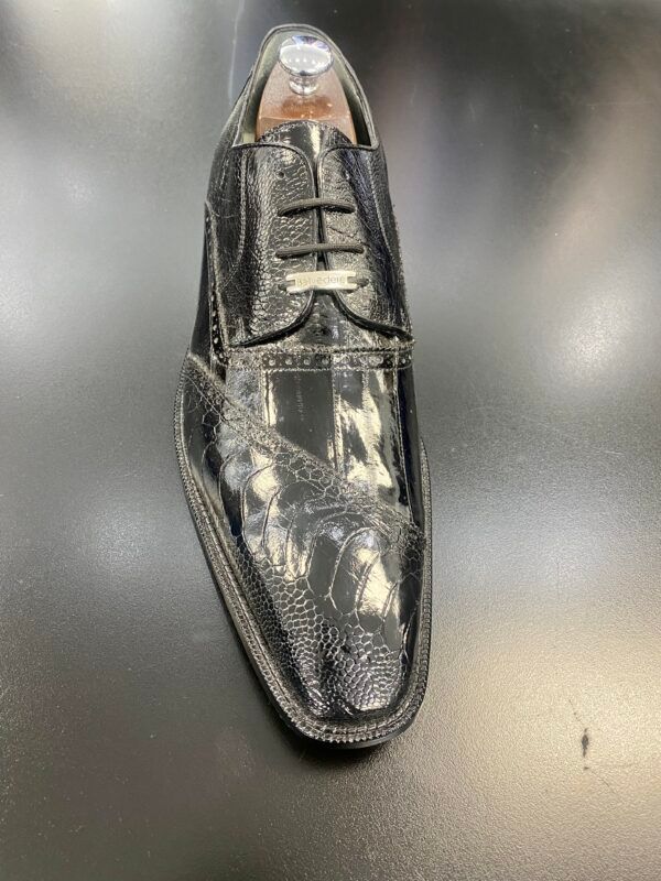 A pair of black shoes sitting on top of a black table.