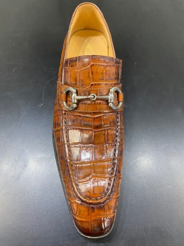 A pair of brown shoes with a buckle on the side