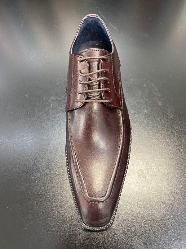 A pair of brown leather shoes are sitting on a black table.