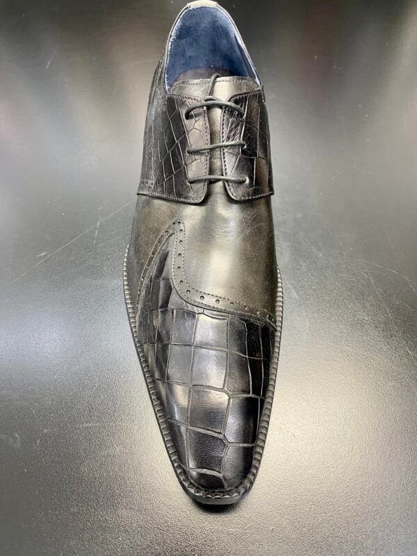 A close up of a pair of black shoes on a table.