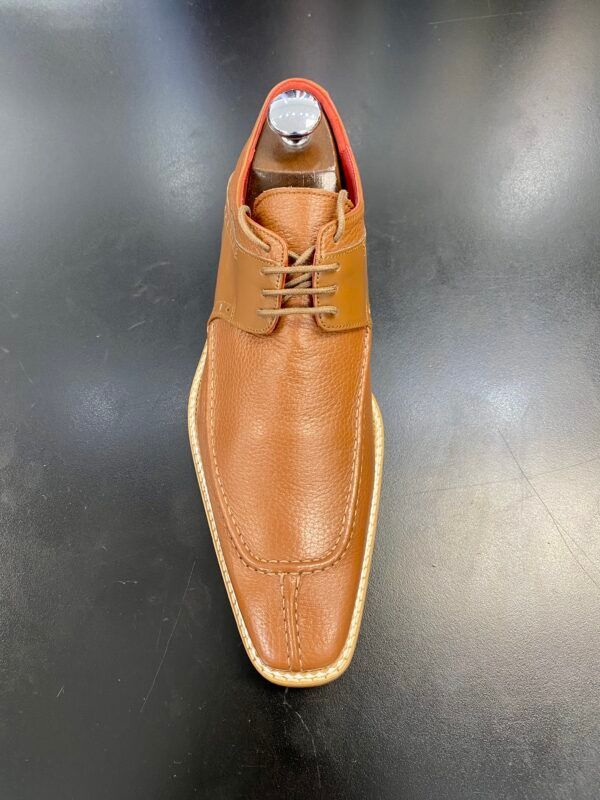 A pair of brown men 's shoes are sitting on a black table.