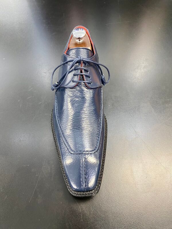 A pair of blue leather shoes are sitting on a black table.