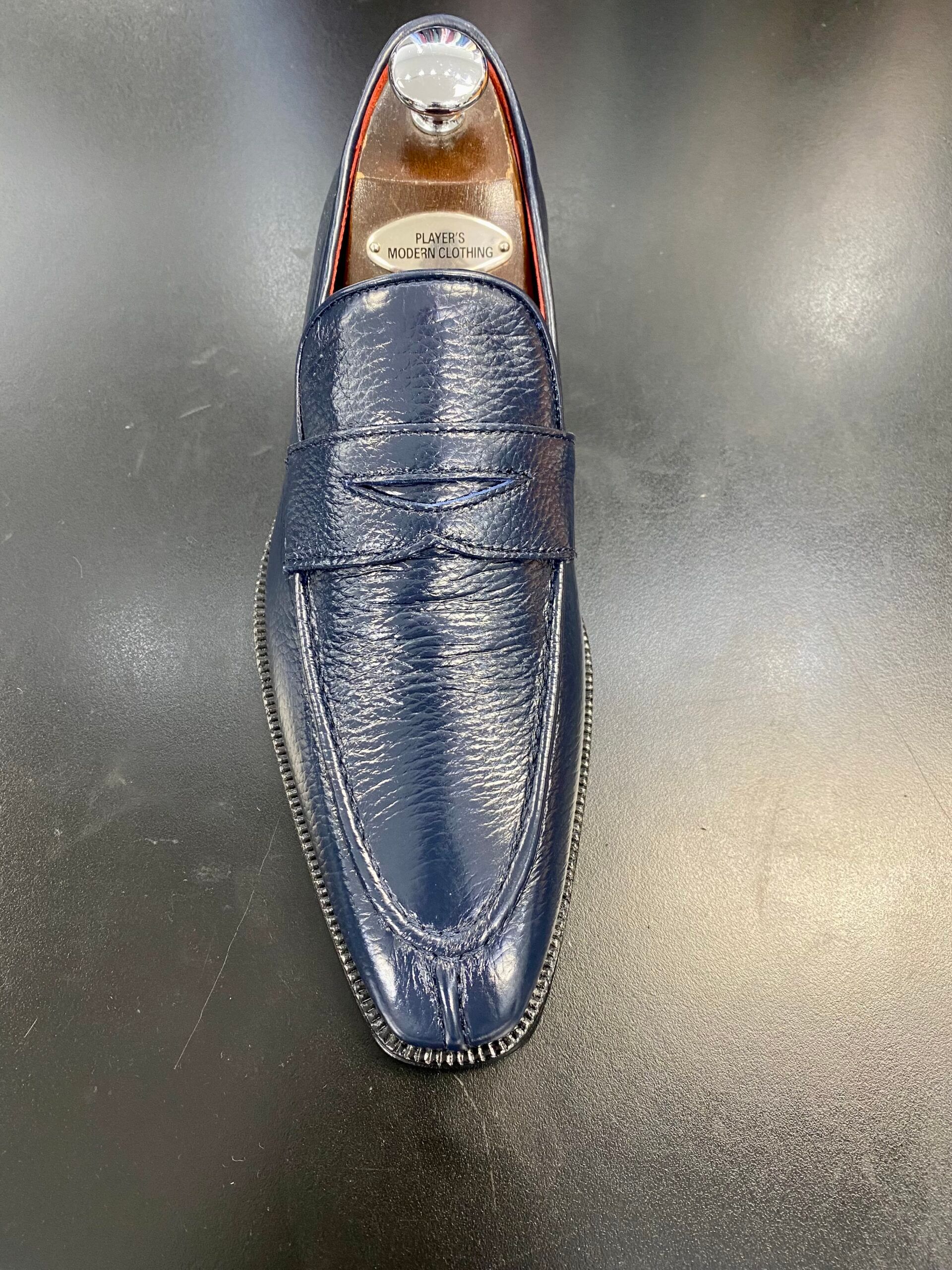 A pair of blue loafers sitting on top of a black table.