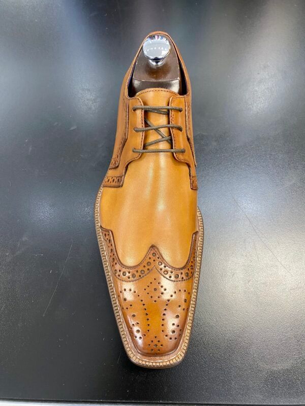 A close up of a brown shoe on a black surface