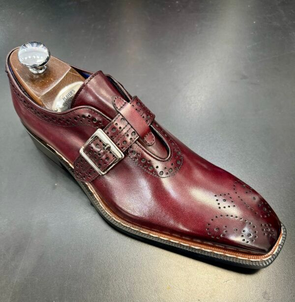 A pair of burgundy shoes on a wooden shoe holder