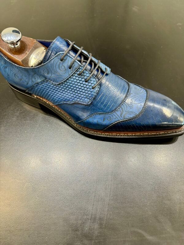 A blue shoe is sitting on top of a black table.