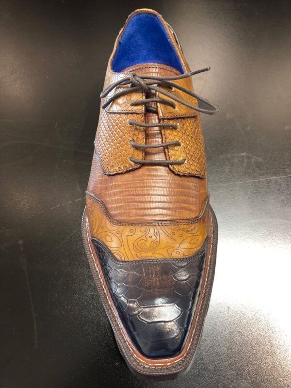 A pair of brown and black shoes with blue laces on a black surface.