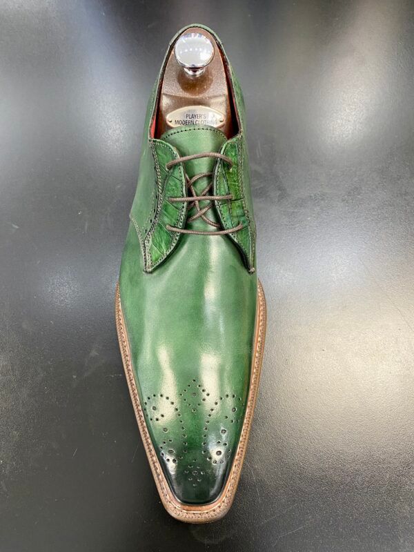 A pair of green shoes are sitting on top of a black table.