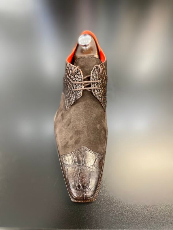 A pair of brown shoes are sitting on top of a black table.