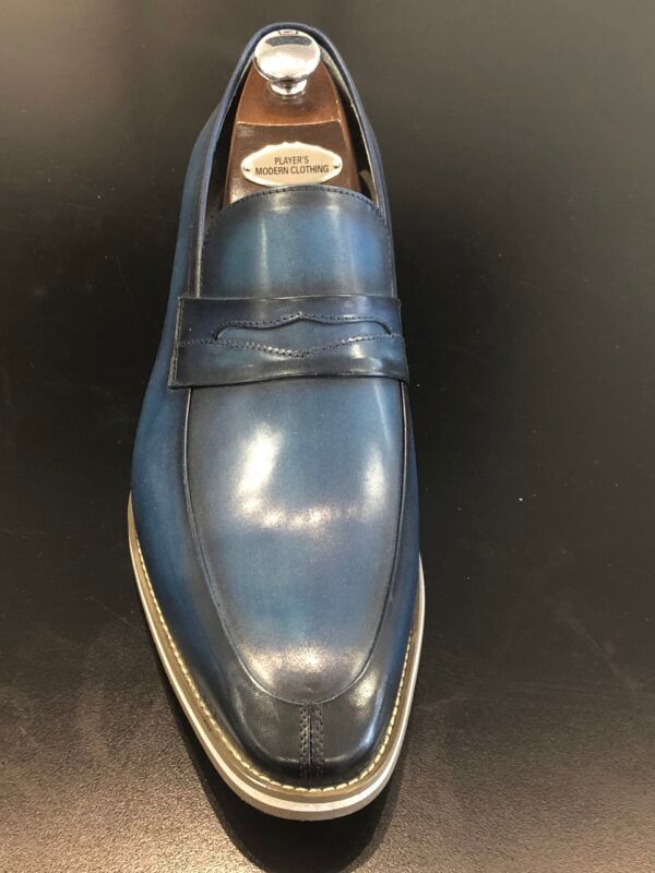 A pair of blue loafers sitting on top of a black table.