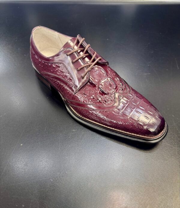 A purple shoe is sitting on a black surface.