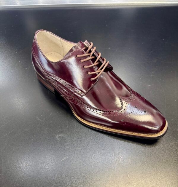 A pair of burgundy lace up shoes on a table