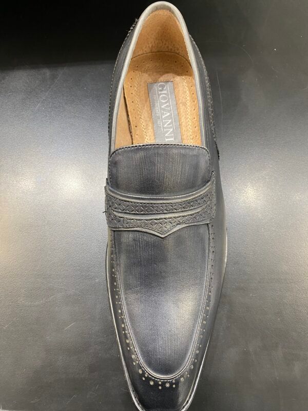 A pair of black loafers sitting on top of a black table.