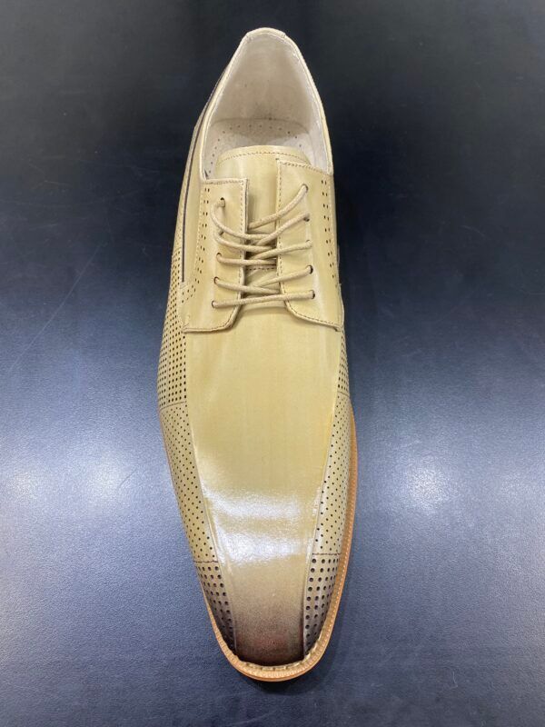 A pair of tan shoes with brown laces on a black surface