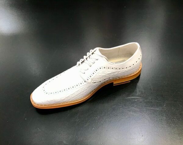 A white shoe is sitting on a black surface.