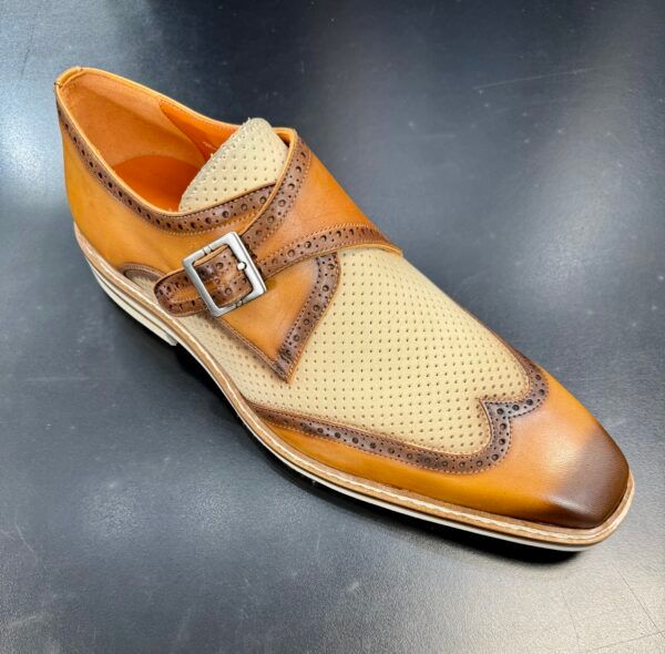 A pair of tan and brown shoes with a buckle on the side