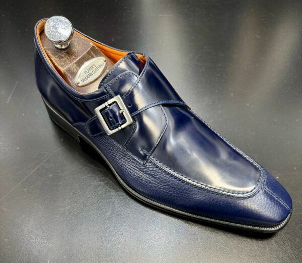 A pair of blue monk strap shoes on a shoe stand