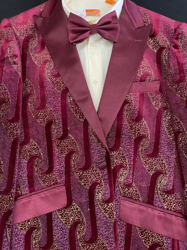 A man wearing a purple tuxedo with a bow tie
